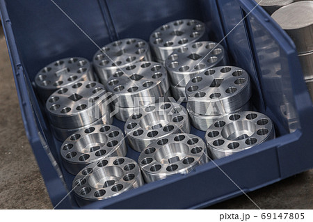 Cylindrical steel metal part with round holes made on lathe in blue case. Metal industry products, workpieces. Steel products to automotive industry. Billet obtained on lathe from steel and cast iron 69147805