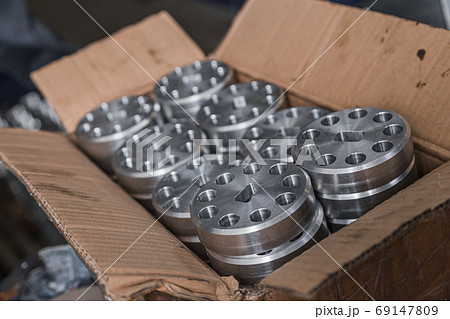 Cylindrical steel metal part with round holes made on lathe in box. Metal industry products, workpieces. Steel products to automotive industry. Billet obtained on lathe from steel and cast iron Cylindrical steel metal part with round holes made on lathe in box. Metal industry products, workpieces. Steel products to automotive industry. Billet obtained on lathe from steel and cast iron 69147809