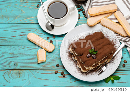 portion of Classic tiramisu dessert, cup of coffee and savoiardi cookies on wooden background portion of Classic tiramisu dessert, cup of coffee and savoiardi cookies on wooden background 69149519
