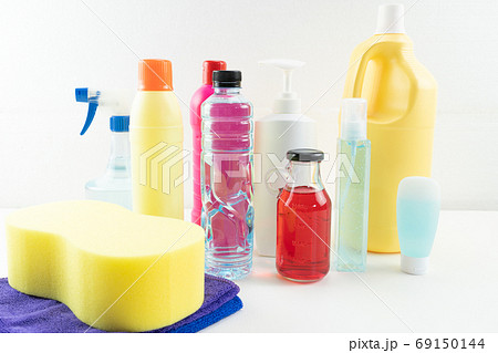 Plastic bottles of cleaning products set with pile clothes on ta 69150144