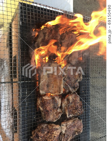 炭火焼きで炎をあげながら焼くチキンステーキ 炭火焼きで炎をあげながら焼くチキンステーキ 69150490