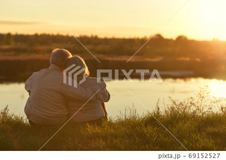 Portrait of senior couple sitting on grass Portrait of senior couple sitting on grass 69152527