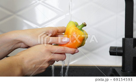 Female hands washing yellow and red color pepper Female hands washing yellow and red color pepper 69154593