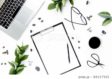 office desk workspace with paper blank, green leaves. Laptop, glasses on white background. Magazines, websites, social media. Flat lay, top view. office desk workspace with paper blank, green leaves. Laptop, glasses on white background. Magazines, websites, social media. Flat lay, top view. 69157505