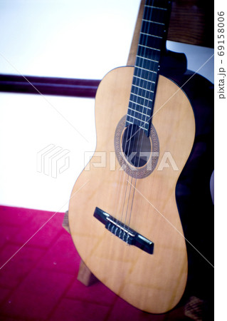 Spanish guitar musical instrument perched on a tripod 69158006