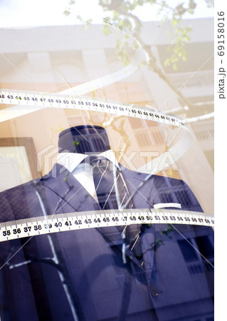 Mannequin in a mens suit surrounded by a tailors tape measure Mannequin in a mens suit surrounded by a tailors tape measure 69158016