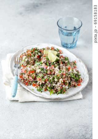 Quinoa Quinua salad with tomatoes and herbs in white bowl 69158183