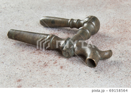 Antique bronze wine barrel crane on concrete background. 69158564