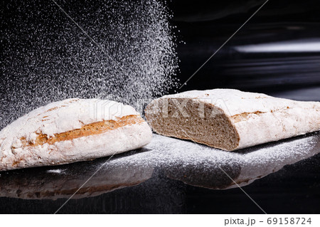 Gray bread sprinkled with flour. Homemade pastries, bread cut gavpil Gray bread sprinkled with flour. Homemade pastries, bread cut gavpil 69158724