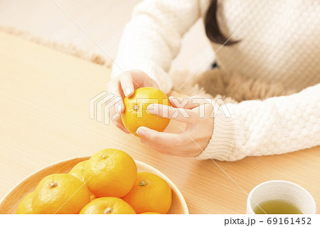 みかんの皮をむく女性 69161452