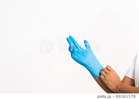 Woman wearing and putting hand to blue rubber latex glove Woman wearing and putting hand to blue rubber latex glove 69161579