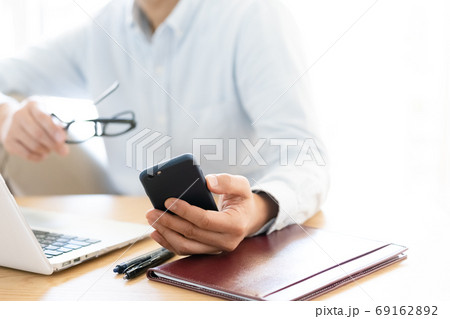 パソコンとスマホを見るミドル男性 69162892