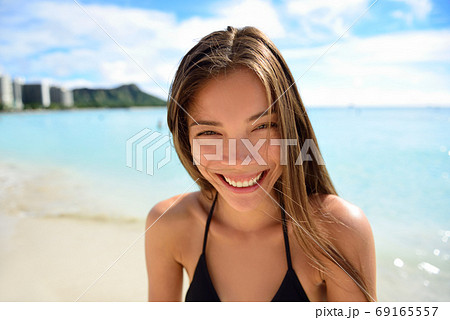 Happy healthy smiling Asian woman - beach vacation Happy healthy smiling Asian woman - beach vacation 69165557