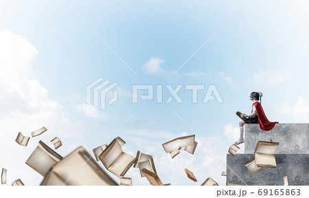 Girl power concept with cute kid guardian against cloudscape background . Mixed media Girl power concept with cute kid guardian against cloudscape background . Mixed media 69165863