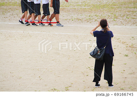 体育祭 運動会 のムカデ競争を撮影する母親の写真素材