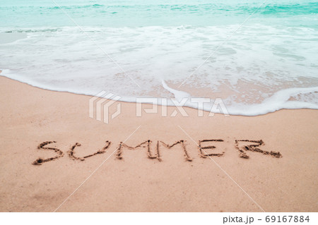 Summer word hand drawn on sand summer beach. 69167884