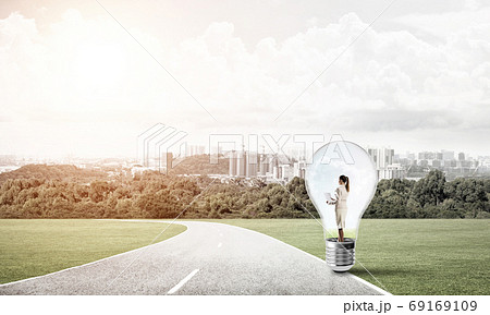 Businesswoman inside light bulb Businesswoman inside light bulb 69169109