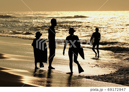 夜明けの海辺のサーファー親子 69172947