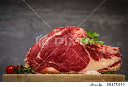 Raw T Bone steak on wooden board prepared to Grill  69173489