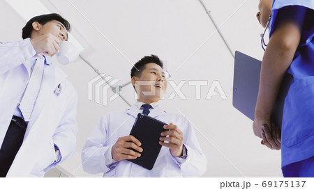 Team of doctors talking in hospital. Group of medical staff discussing in clinic. Team of doctors talking in hospital. Group of medical staff discussing in clinic. 69175137
