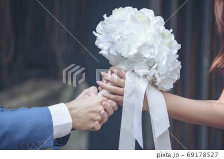 Caucasian handsome man giving flowers to asian girlfriend asking for proposing to marry Caucasian handsome man giving flowers to asian girlfriend asking for proposing to marry 69178527