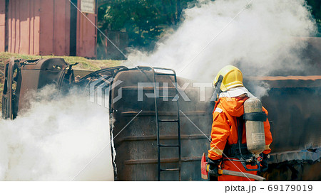Firefighter fighting with flame using fire hose chemical water  69179019
