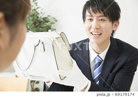 査定する鑑定士と客 69179174