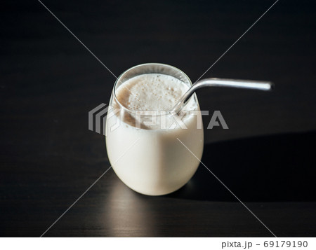 Protein milkshake in glass with metal straw 69179190