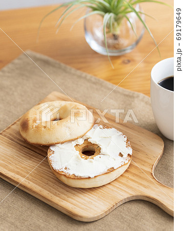 トーストしたベーグルにクリームチーズを塗る 69179649