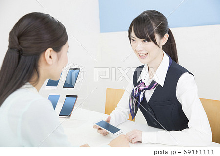 接客する携帯ショップの店員 69181111