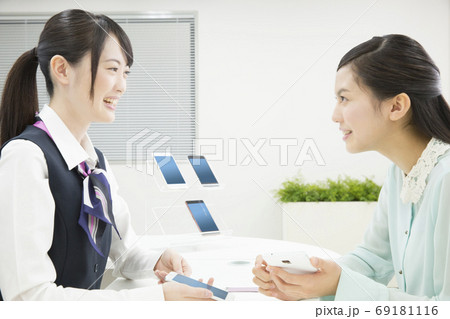 接客する携帯ショップの店員 69181116