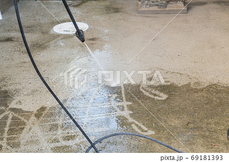 高圧洗浄機でコンクリートの汚れを落とす場面の写真素材