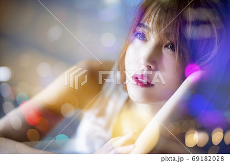 窓の外の夜景を眺める女性のイメージ 69182028