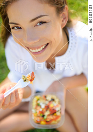 Woman eating gluten free pasta salad Woman eating gluten free pasta salad 69183583