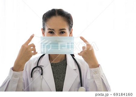 Asian female doctor wearing medical mask isolated on white background. Coronavirus outbreak. Asian female doctor wearing medical mask isolated on white background. Coronavirus outbreak. 69184160