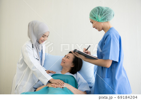 Asian female doctors examination and treating  female patient in a hospital room 69184204