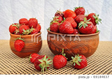 Strawberries in pottery on a wooden table. Side view 69184637