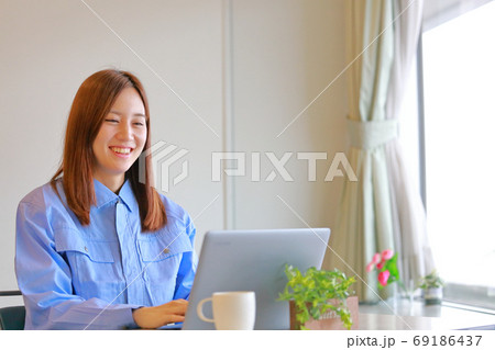 ユニフォームの女性_笑顔でデスクワーク ユニフォームの女性_笑顔でデスクワーク 69186437
