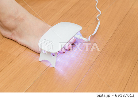 ネイルシールを固める女性の足元 69187012