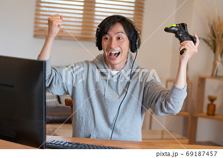 オンラインゲームに熱狂する若い男性 オンラインゲームに熱狂する若い男性 69187457