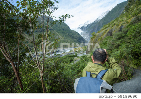ニュージーランド、南島、ウェストランド国立公園のフランツ・ジョセフ氷河を旅行するアクティブシニア男性 69189690