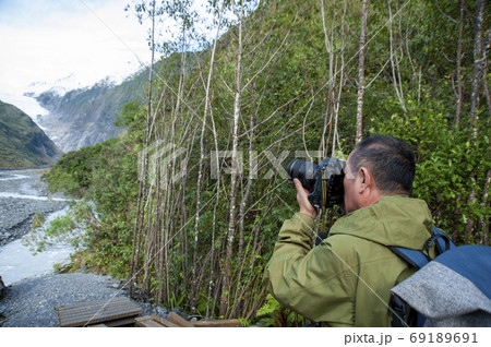 ニュージーランド、南島、ウェストランド国立公園のフランツ・ジョセフ氷河を旅行するアクティブシニア男性 69189691