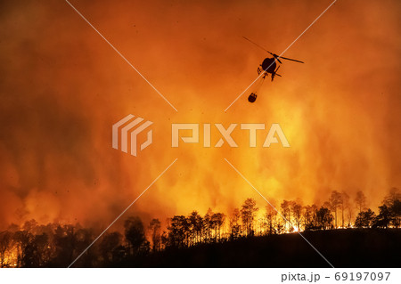 Fire fighting helicopter carry water bucket to extinguish the fo 69197097