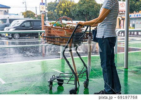 雨の日のショッピング　雨が止むのを待つエコマイカゴを持つ女性 69197768