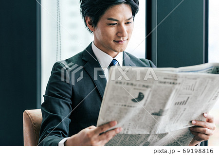 新聞を読むビジネスマンの写真素材