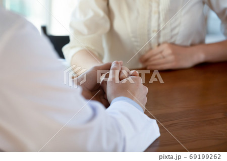 Close up caring doctor holding young woman hand, empathy concept 69199262