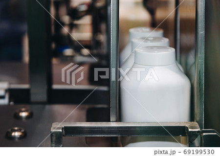 white plastic bottle of baby powder products in conveyor belt moving to packing machine in the cosmetic factory. 69199530