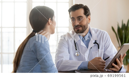 Doctor therapist consulting patient at meeting, using computer tablet 69199561