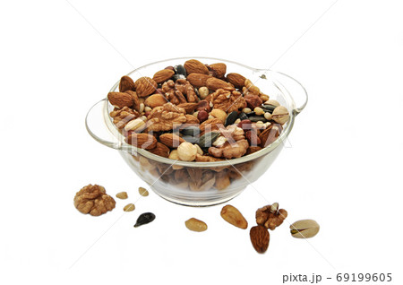 Assorted different nuts in a transparent plate on a white background Assorted different nuts in a transparent plate on a white background 69199605