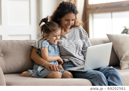 Happy mother with little daughter have fun online use laptop 69202561